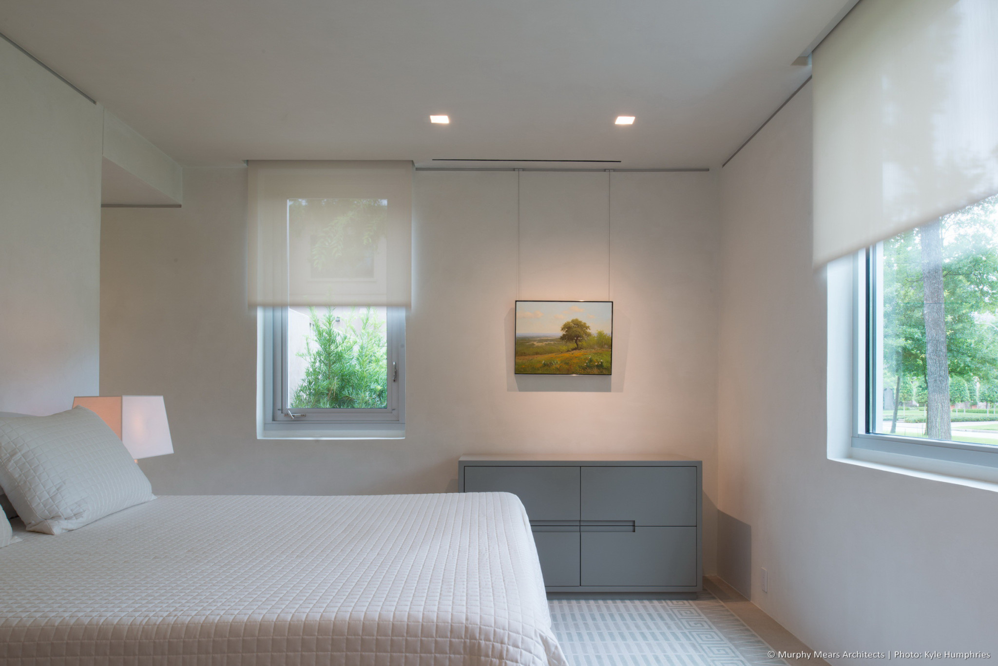 Guest bedroom with automated shades raising into hidden pockets above the West and South windows.