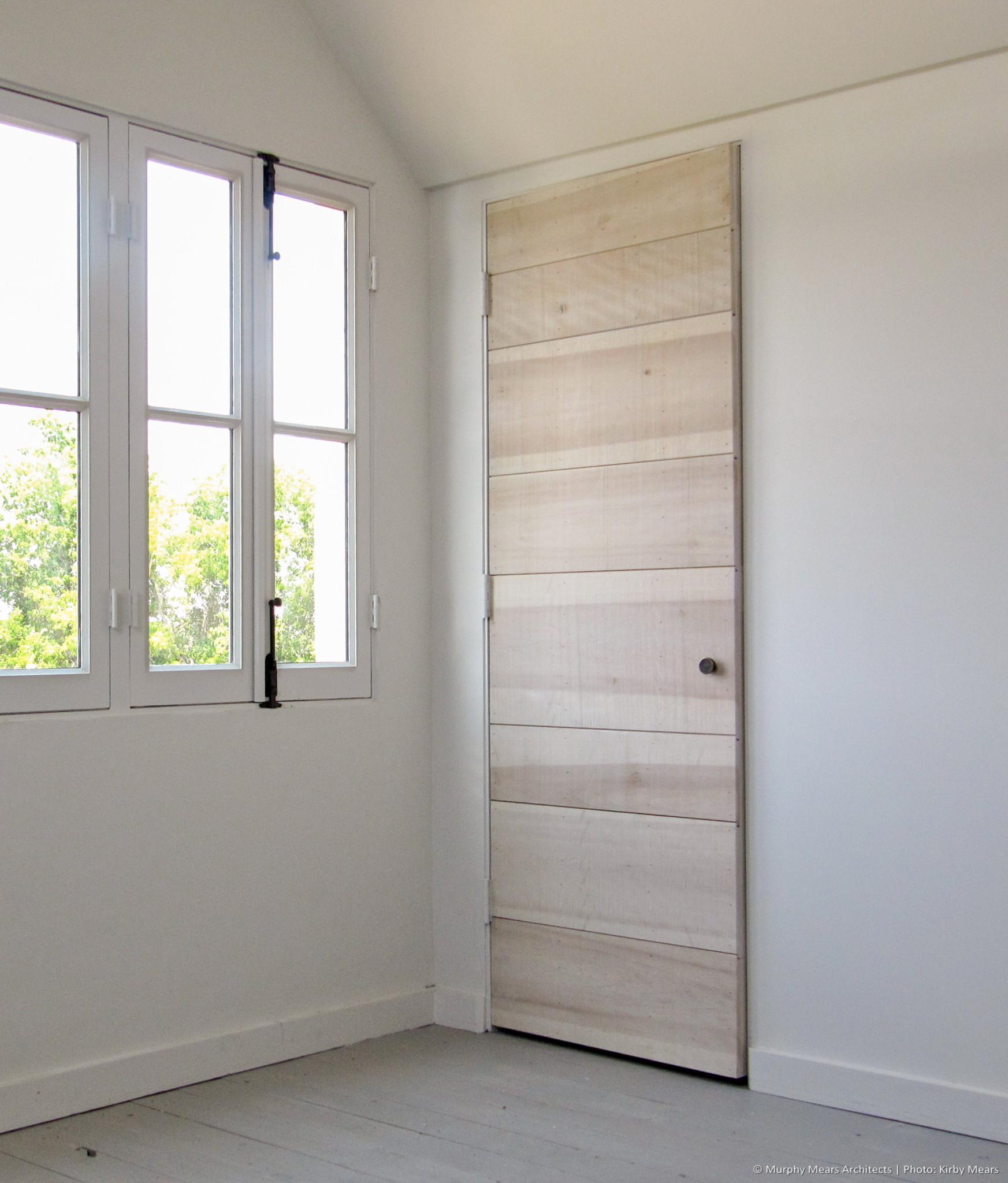 Typical interior door: custom flush wood plank construction.